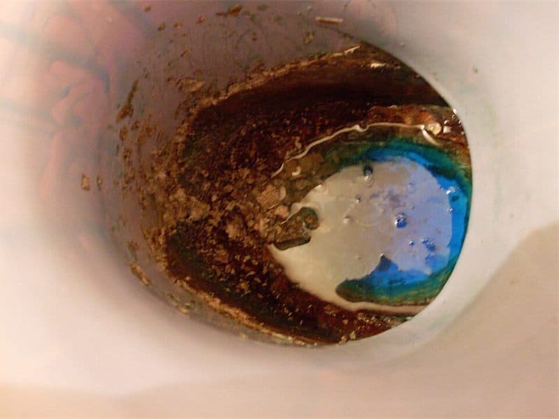 Capa de cal acumulada en el interior de un inodoro