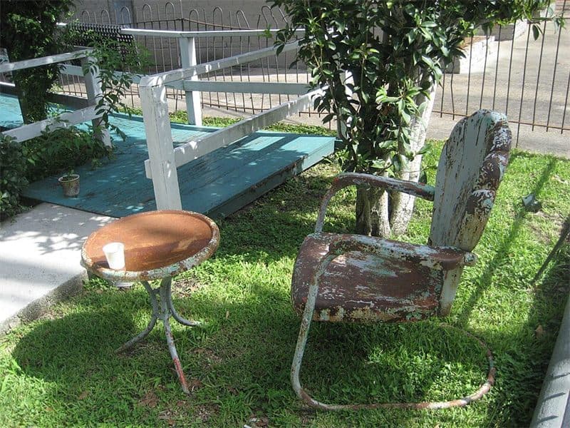 Mesa y sillas de hierro oxidadas en el exterior