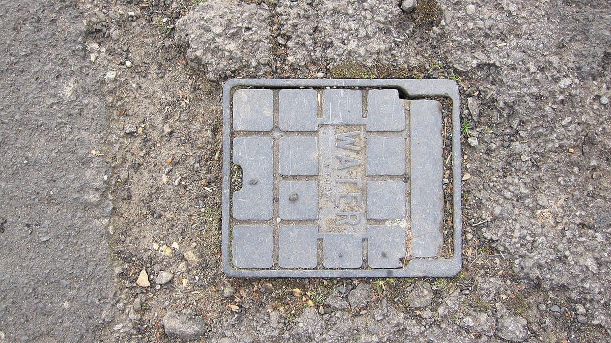 Llave de paso de agua protegida por una tapa en el exterior