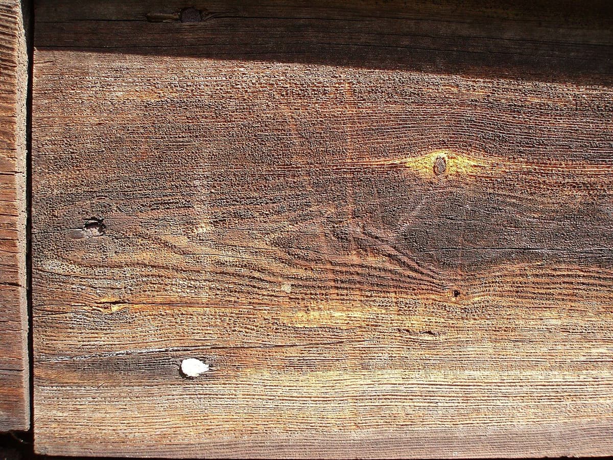 Tabla de madera con la superficie astillada tras un golpe